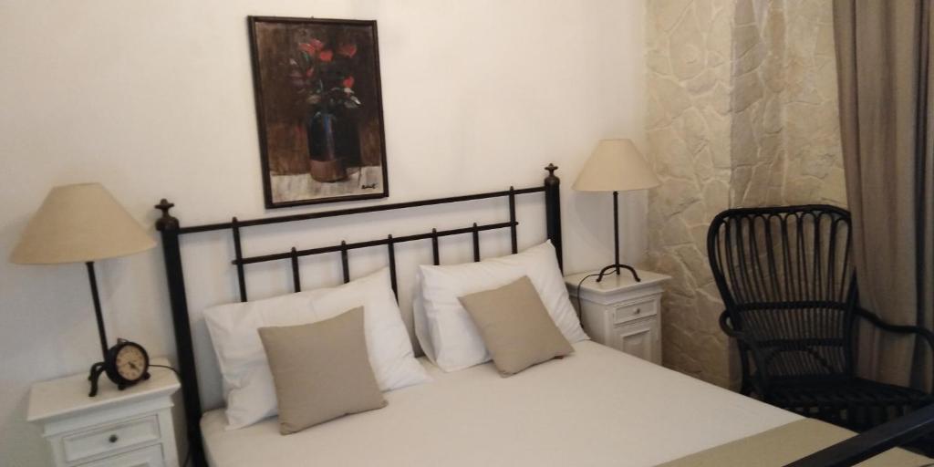 ein Schlafzimmer mit einem Bett mit weißen Kissen und zwei Lampen in der Unterkunft Apartman Victoria in Gradac
