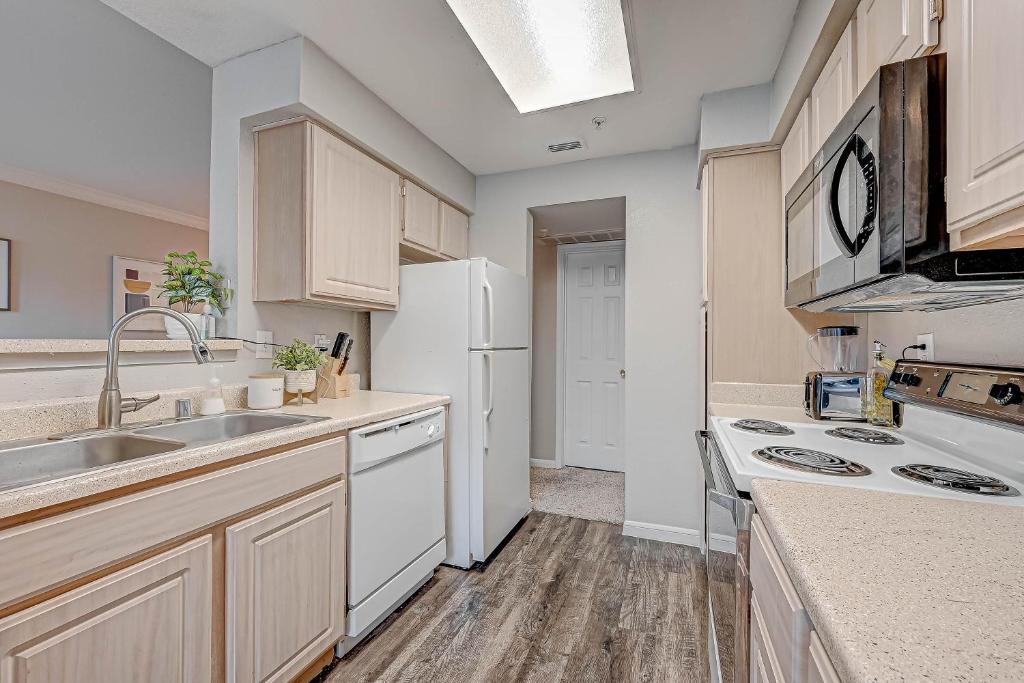 a kitchen with a sink and a white refrigerator at Med Center Urban living in Houston