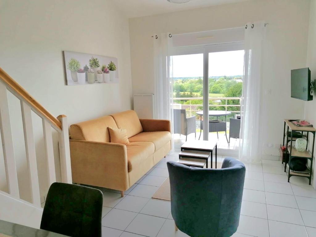 ein Wohnzimmer mit einem Sofa und einem Stuhl in der Unterkunft LaConciergerieJonzac Appart 1 chambre Cocooning in Jonzac