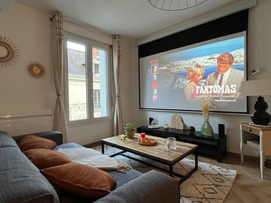 - un salon avec un canapé et un grand écran dans l'établissement T3 cinéma - Centre historique, bord de Loire, à Tours