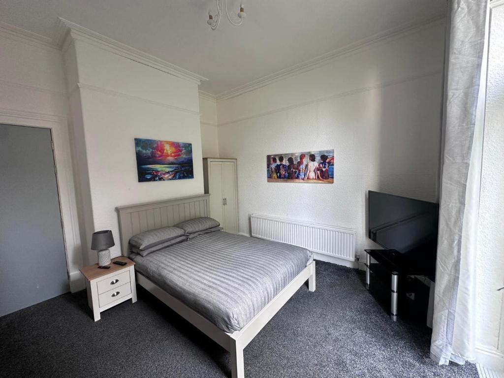 a bedroom with a bed and a flat screen tv at @22 in Rock Ferry