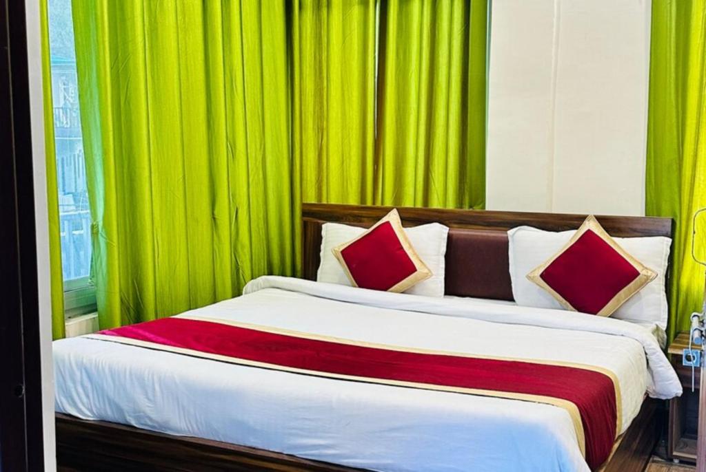 1 dormitorio con 1 cama grande y cortinas verdes en Goroomgo Morning Moon Bhimtal Near Ramleela Ground - Comfortable Stay with Family, en Bhimtal
