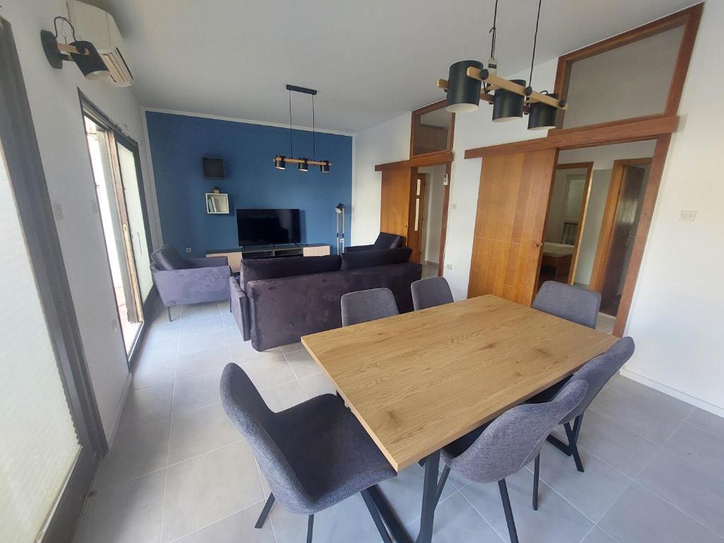 Un comedor con mesa y sillas de madera. en Apartman Lili Podgora, en Podgora