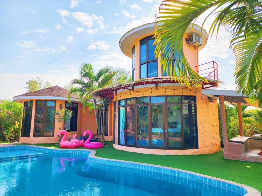 ein Haus mit einem Pool vor einem Haus in der Unterkunft ฺBuena Vista Pool Villa Hua Hin (บ้านพักหัวหิน) in Hua Hin