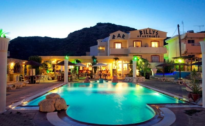 a large swimming pool in front of a building at Billy's Studios in Faliraki