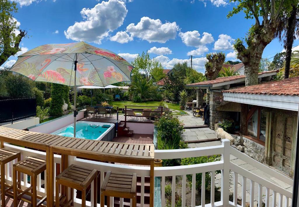 a deck with an umbrella and a pool at Villa AJNA Bayonne in Bayonne