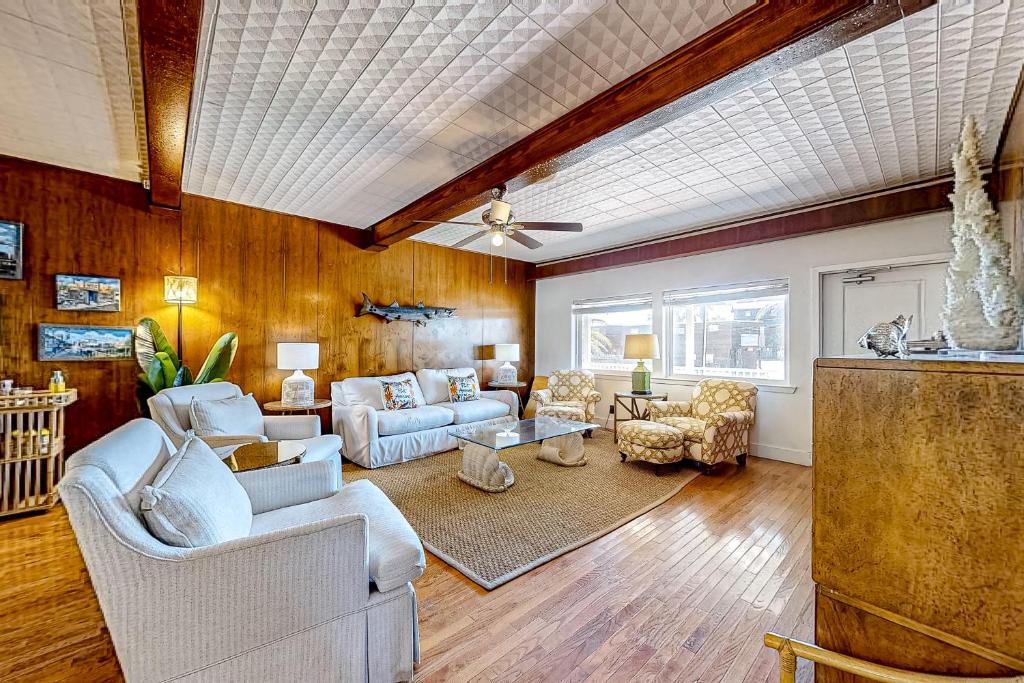 a living room with wood paneling and a ceiling at Old Town Treasure in Port Aransas