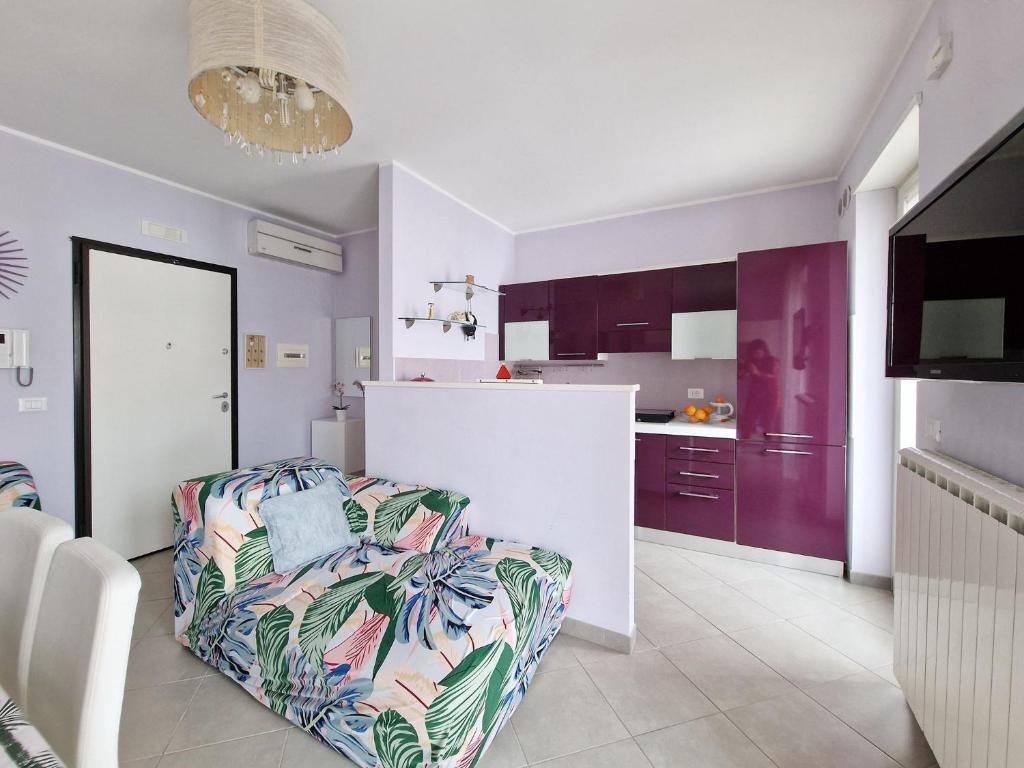 a living room with a couch and a kitchen with purple cabinets at Casa Rosaria in Lecce