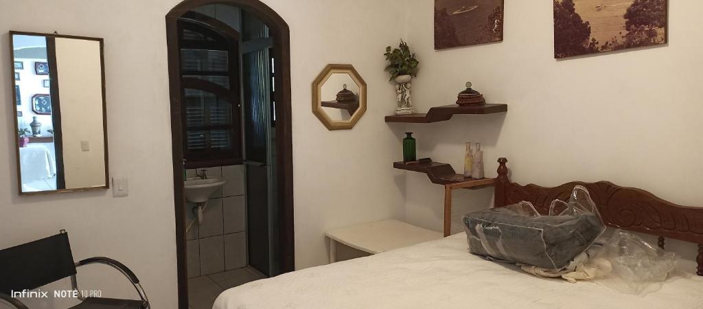 Schlafzimmer mit einem Bett, einem Spiegel und einem Waschbecken in der Unterkunft Paraíso da ilha in Paranaguá