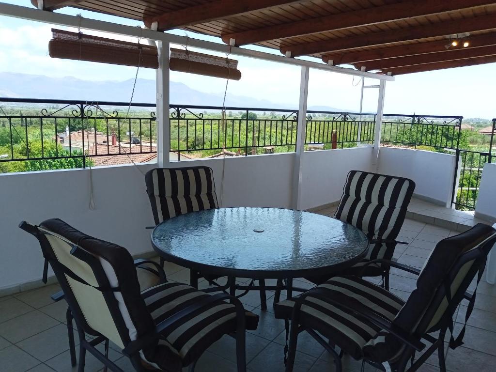 einen Tisch und Stühle auf einem Balkon mit Aussicht in der Unterkunft INFO στούντιο in Messini