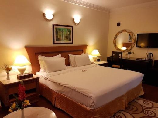 um quarto de hotel com uma cama grande e duas lâmpadas em Furnished Deluxe Private Studio Apartments near Union Metro Station em Dubai