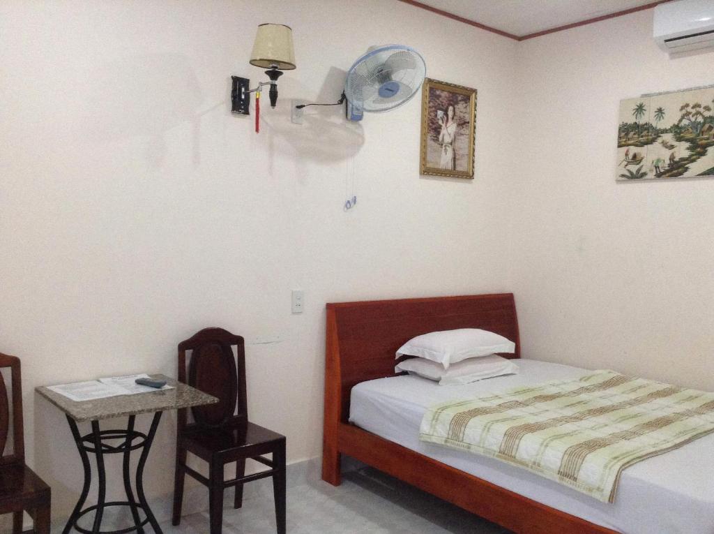 1 dormitorio con 1 cama y 1 mesa con ventilador en 247C/A Guest House, en Mui Ne