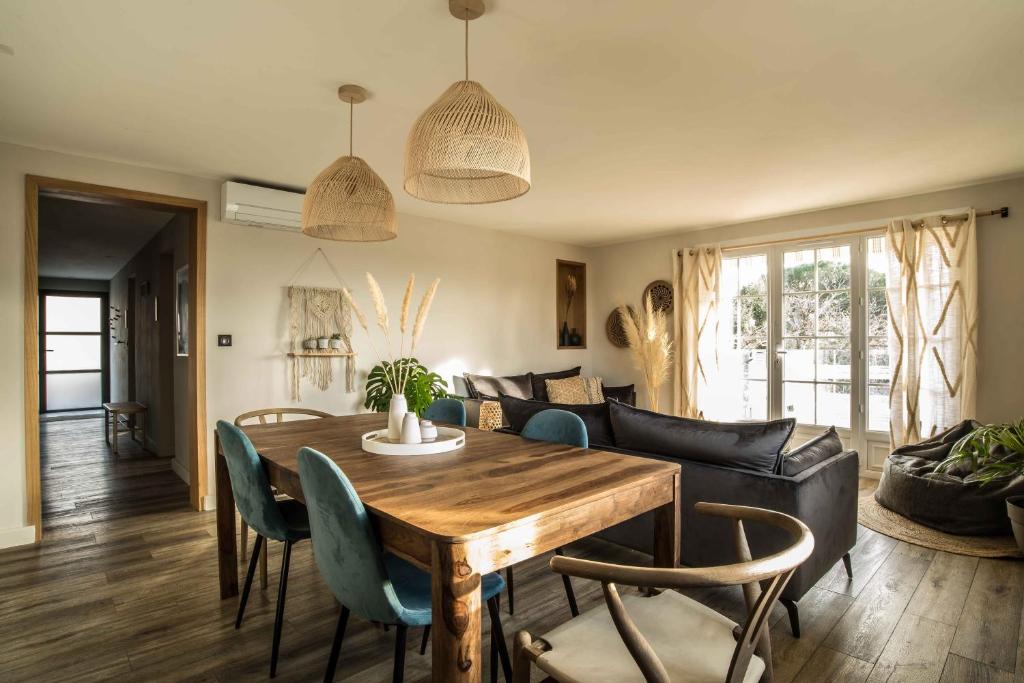 a living room with a wooden table and chairs at Villa de 90m² à 5 minutes de la mer, terrasse 50m² in Sainte-Maxime