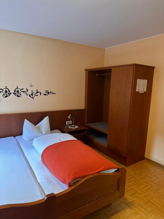 a bedroom with a bed and a small cabinet at Gästehaus Krone in Holzkirchen