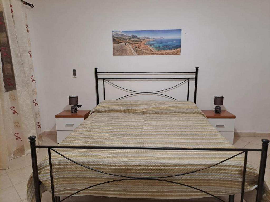 uma cama num quarto com uma fotografia na parede em la casa del nonno em Trapani