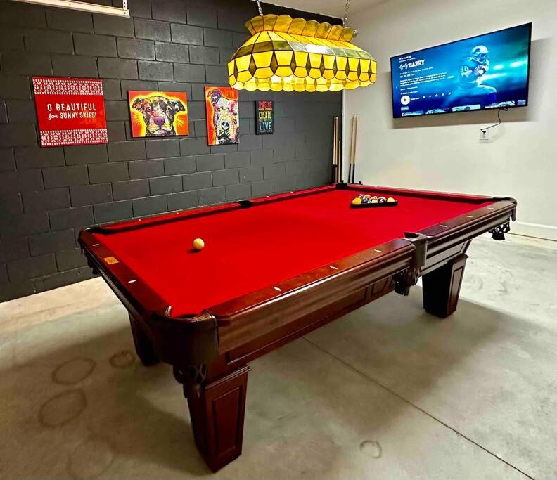 a red snooker table in a room with avertisement at The Billiard close to downtown with fenced yard in Sanford