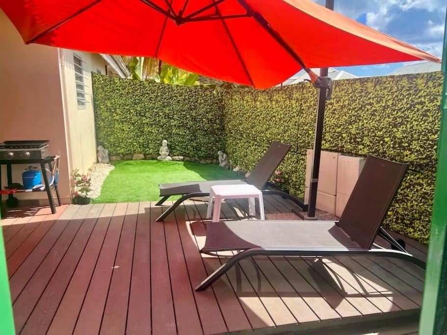 2 chaises et un parasol sur une terrasse en bois dans l'établissement Loc. Ste-Anne, maisonnette plein-pieds 2 à 4 pers., à Sainte-Anne