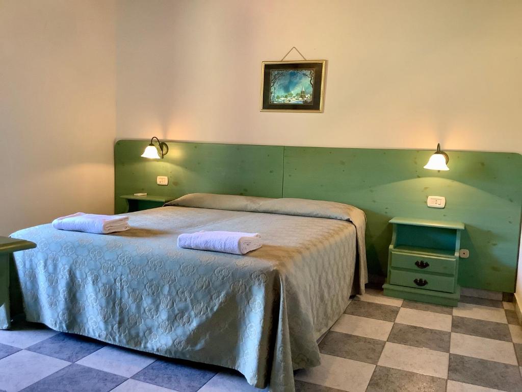 a bedroom with two beds and a green wall at Hotel Golfo del Leone in Portixeddu