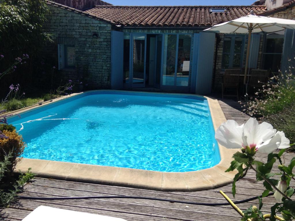 une piscine avec une terrasse en bois et une piscine dans l'établissement Welcome les Portes, aux Portes