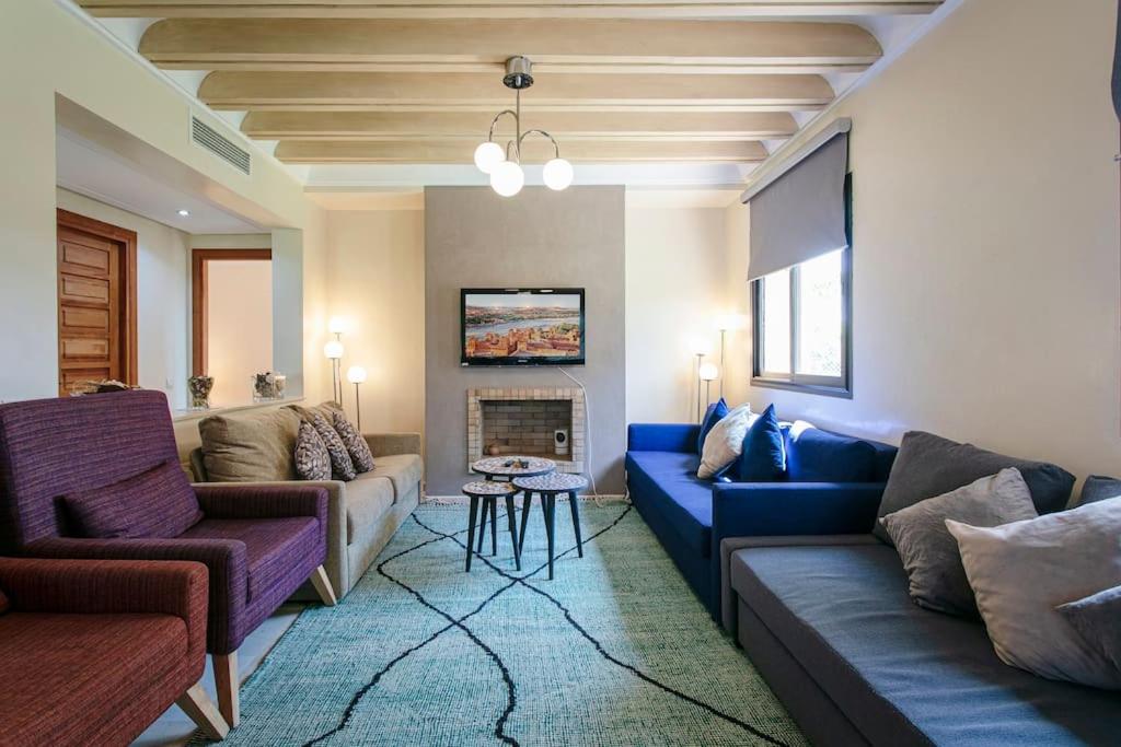sala de estar con 2 sofás y chimenea en Solarium Retreat - Marrakech, en Dar Caïd Layadi