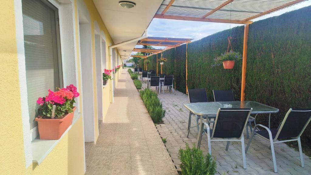 an outdoor patio with tables and chairs and plants at Cozy Room with garden in Bratislava in Bratislava