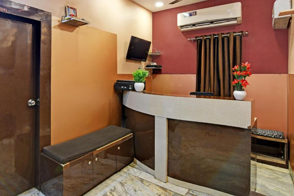 a waiting room with a counter and a television at Super OYO Padmavati Projects Pvt Ltd Near Netaji Subhash Chandra Bose International Airport in Dum Dum