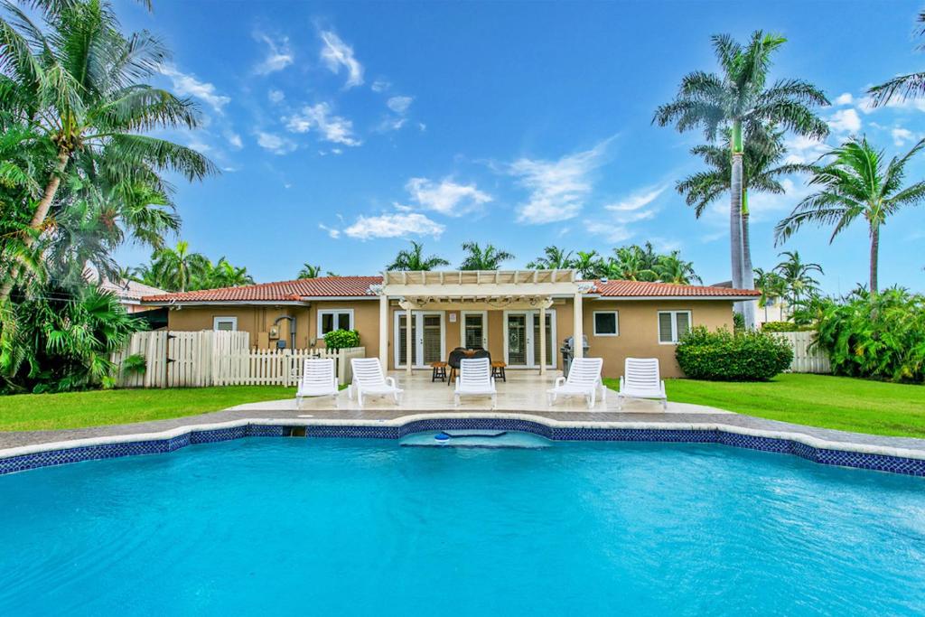 a house with a swimming pool in front of a house at Walk to Beach Luxury 5BR & 3BA Villa Hollywood Lakes in Hollywood