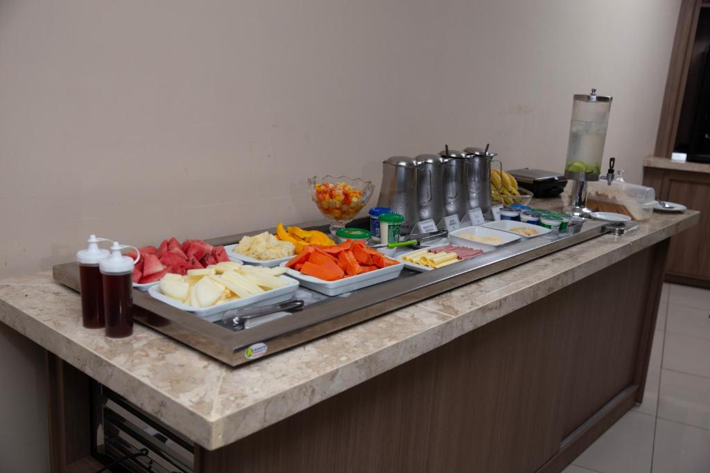 un buffet con molti piatti da mangiare su un bancone di Oasis Hotel a Cajazeiras
