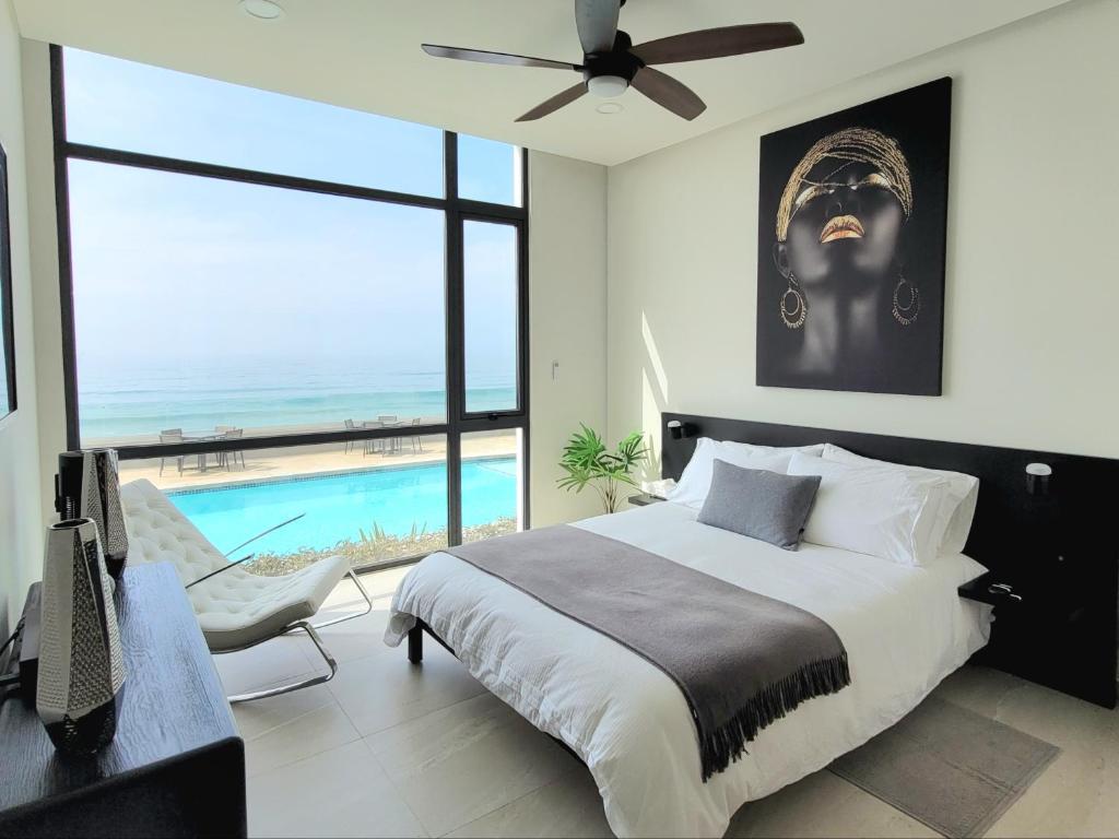 a bedroom with a large bed and a swimming pool at Luxury Beachfront Condo in Rosarito with Pool & Jacuzzi in Rosarito