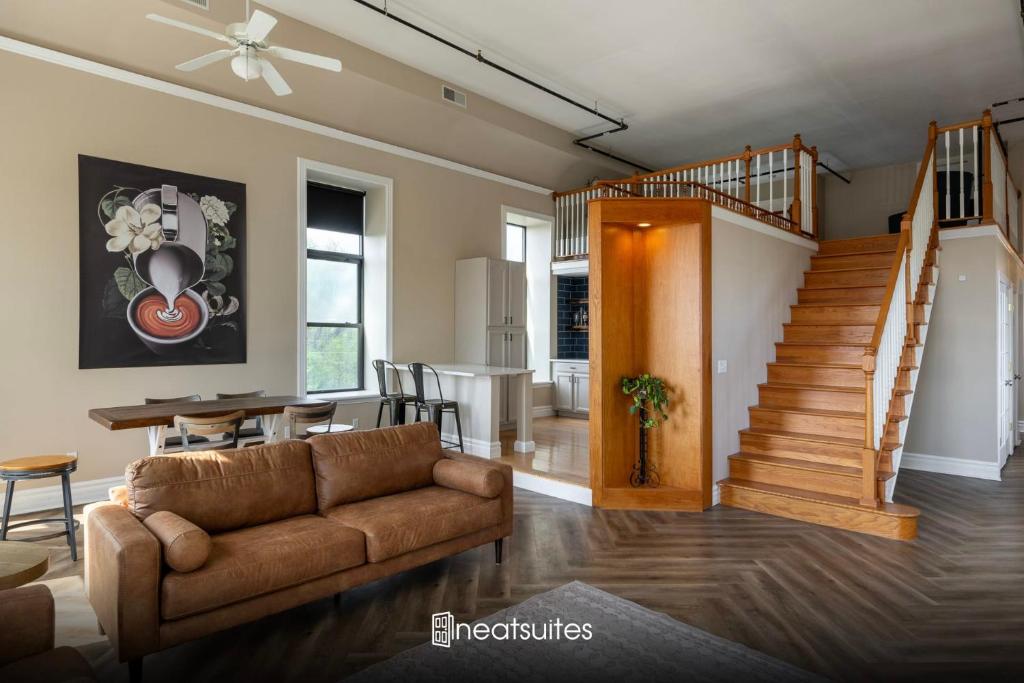 een woonkamer met een bank en een trap bij Mason's View - Cincy Hilltop Apartment in Cincinnati