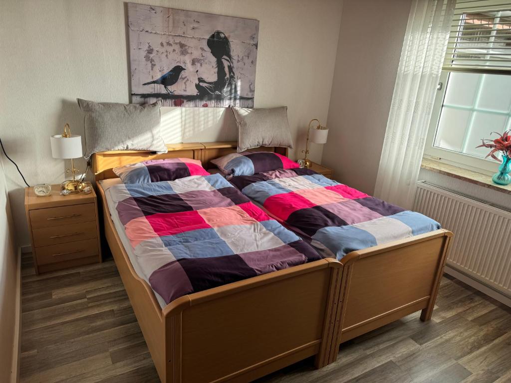 ein Bett mit farbenfroher Bettdecke in einem Schlafzimmer in der Unterkunft Schwalbenhof in Westerstede