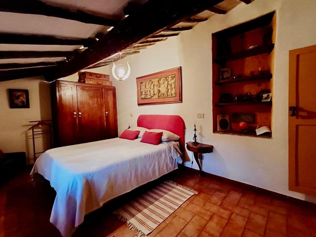 una camera con un letto bianco e una sedia rossa di Borgo Vecchio a Carbognano