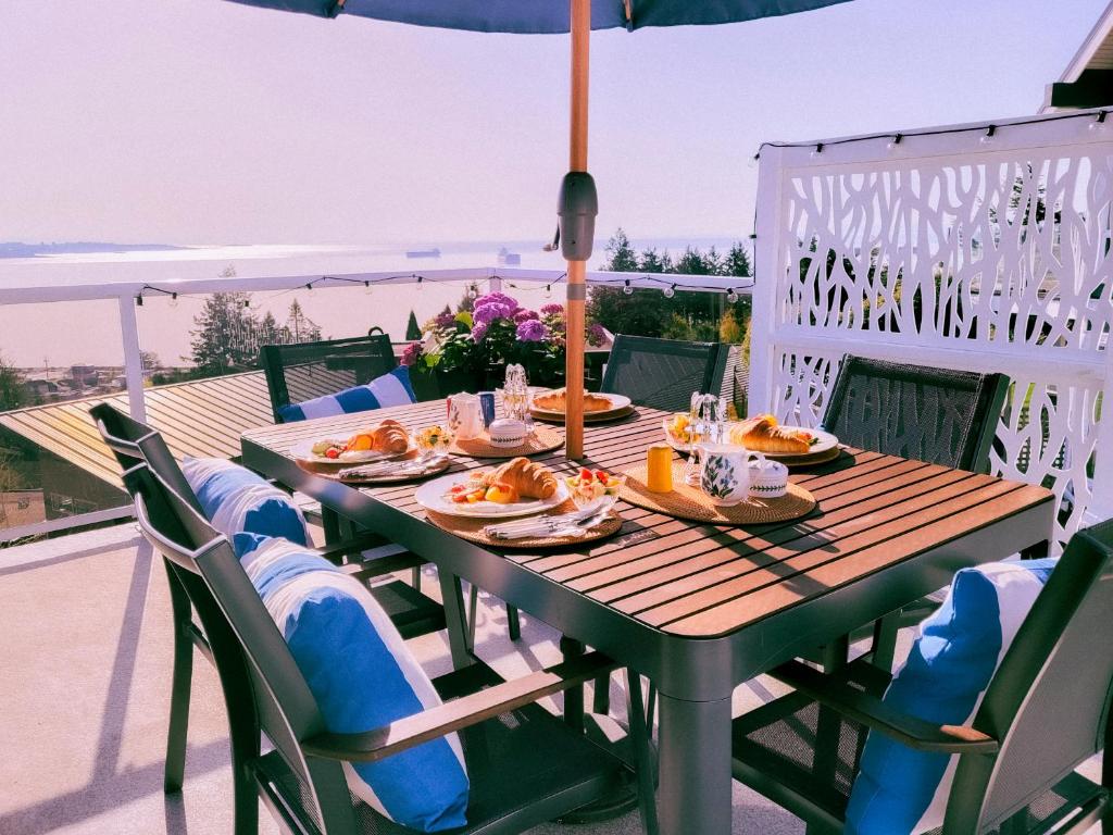 una mesa de madera con platos de comida. en HOV B&B House -Hospitality Ocean View Victoria-, en Victoria