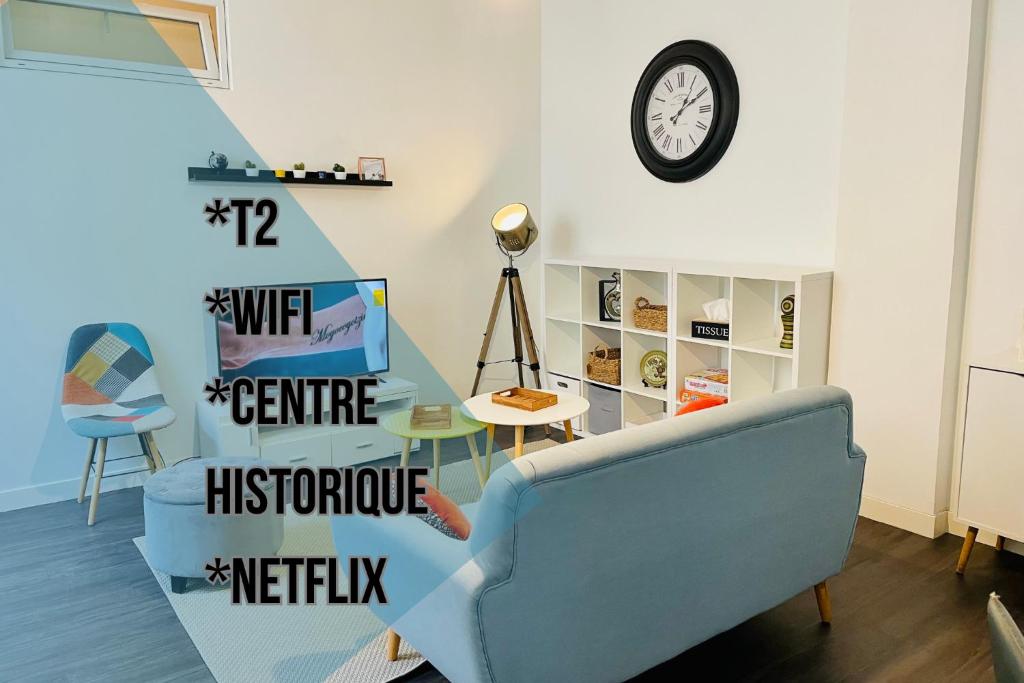 a living room with a blue couch and a clock at L'appartement du Temple à Vienne in Vienne