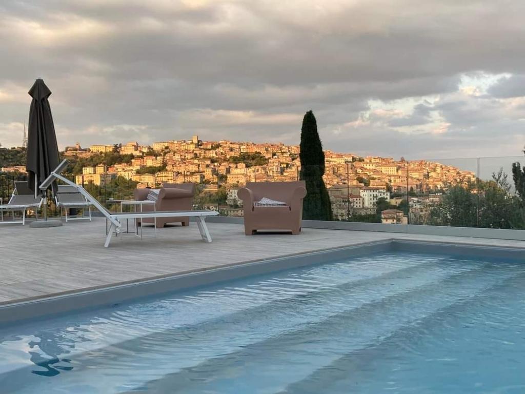 uma piscina com cadeiras e vista para a cidade em Villa Allegrini em Segni