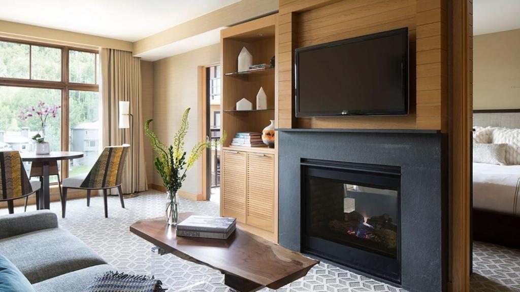 a living room with a fireplace with a flat screen tv at Snowmass Viceroy 1 Bedroom Residence in Snowmass Village