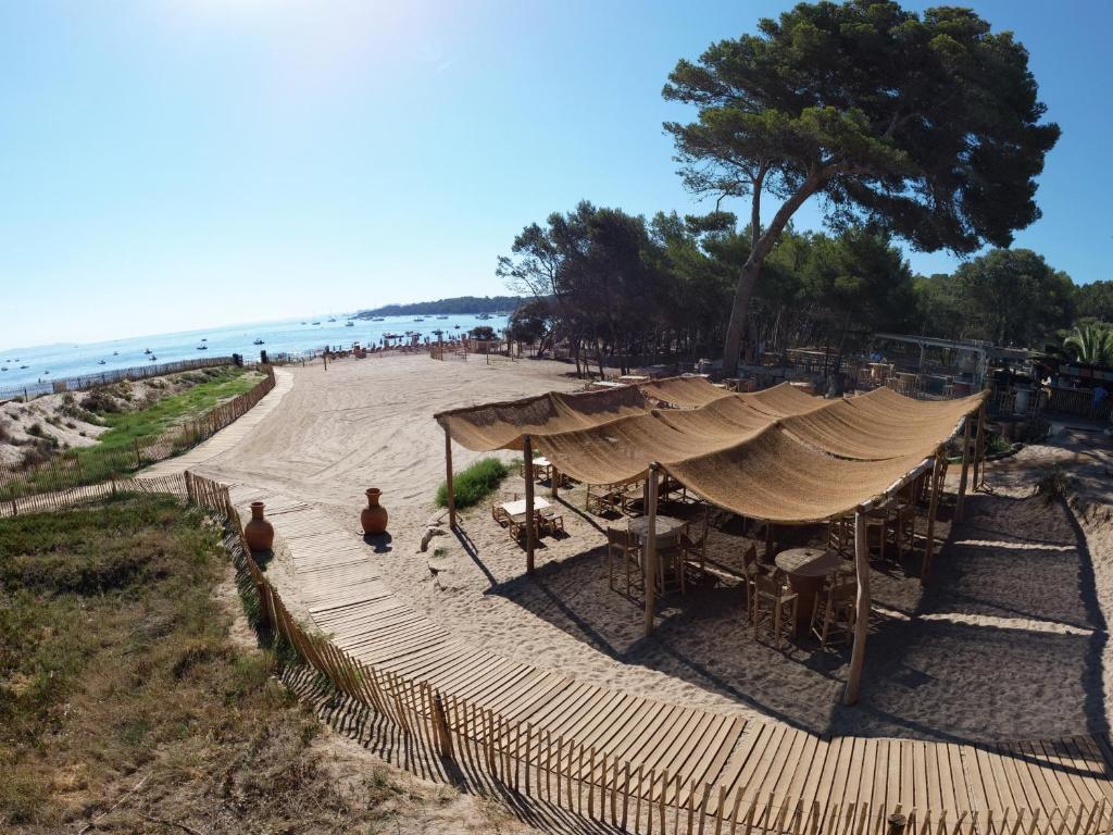 イエールにあるLe Domaine de la mer - Beachhotel Nature&Authenticite Hyèresのテント付きのビーチの景色を望めます。