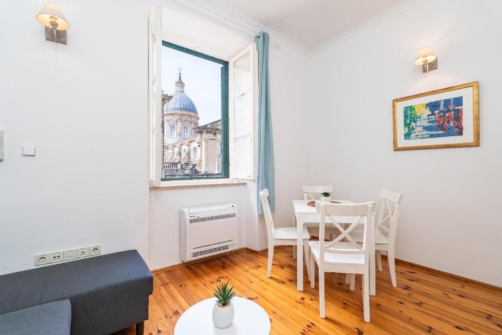 a living room with a table and chairs and a window at Kenova Apartments Old Town in Dubrovnik