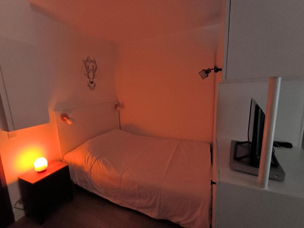 a small bedroom with a bed and a television at studio tout équipé in Jausiers