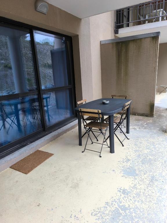 a black table and chairs in front of a building at studio tout équipé in Jausiers