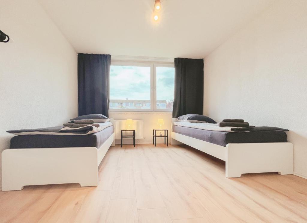 2 Betten in einem Zimmer mit Fenster in der Unterkunft Home4Now DOR02 Gemütliche Monteursunterkunft in Dormagen in Dormagen