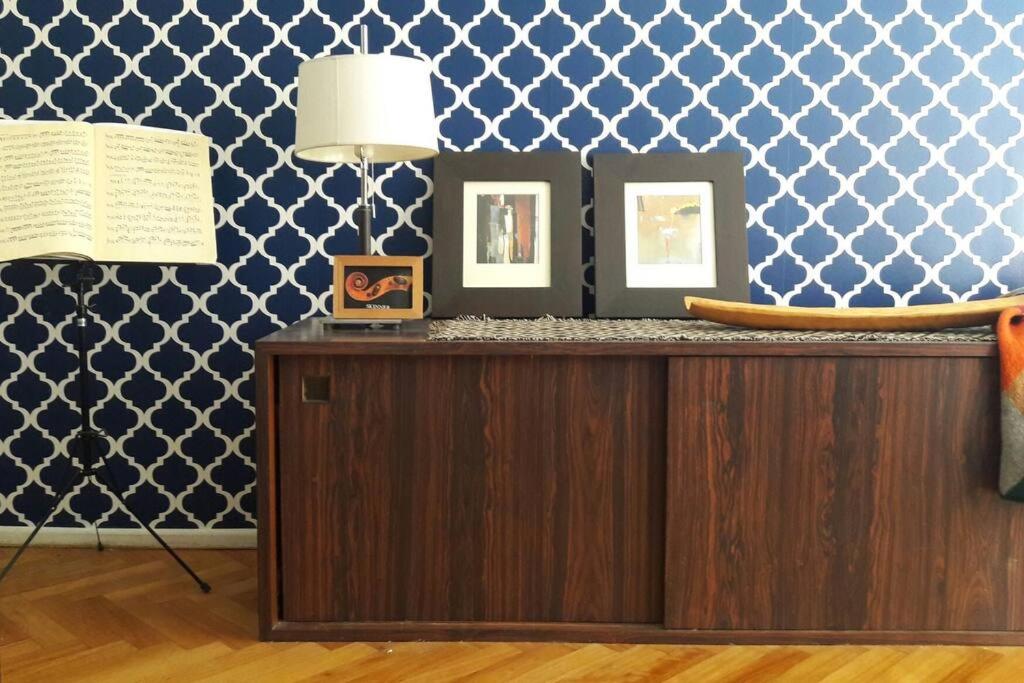 ein Zimmer mit einem Schreibtisch mit zwei Bildern und einer Lampe in der Unterkunft Av.Alvear/Patio Bullrich/Four Seasons Hotel area. in Buenos Aires