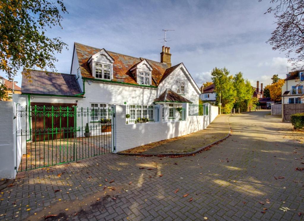 a white house with a fence and a driveway at UNIQUE COUNTRY COTTAGE Nr NATURE RESERVE Sleeps 4 in London