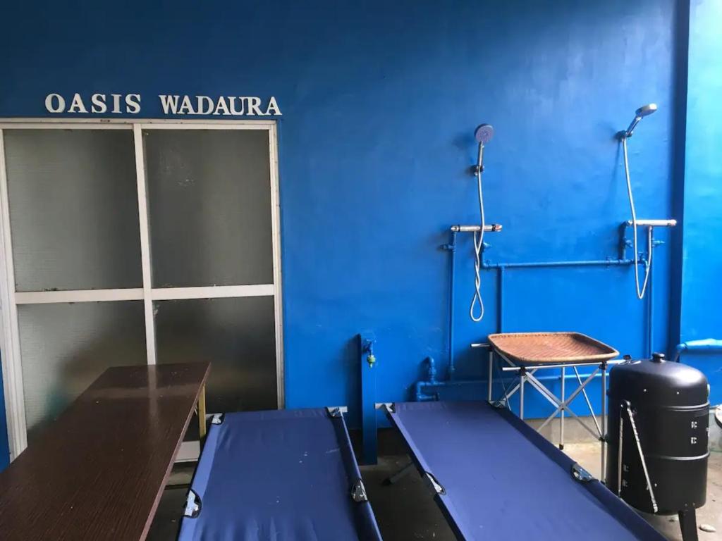 Zimmer mit einer blauen Wand und einem Tisch in der Unterkunft Oasis Wadaura - Vacation STAY 67404v in Kamogawa