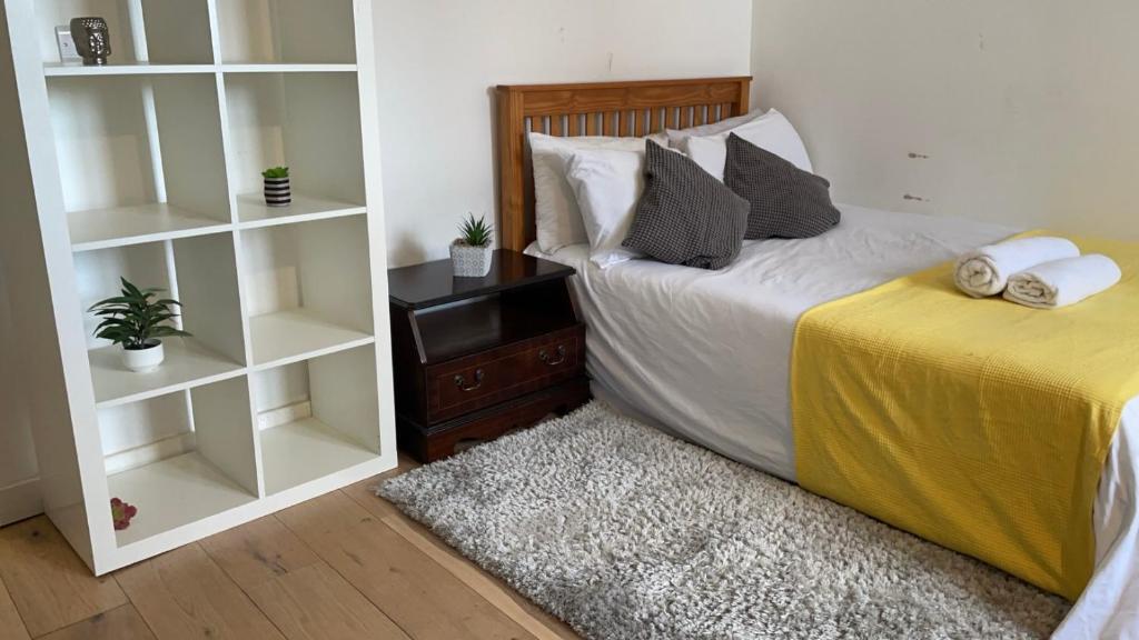 a bedroom with a bed and a book shelf at Kirkgate Aprt4 - Duplex Relocations in Wakefield