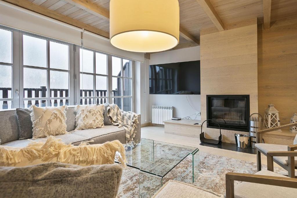 a living room with a couch and a fireplace at Luderna - Casa Val de Ruda IV des Artiguetes in Baqueira-Beret
