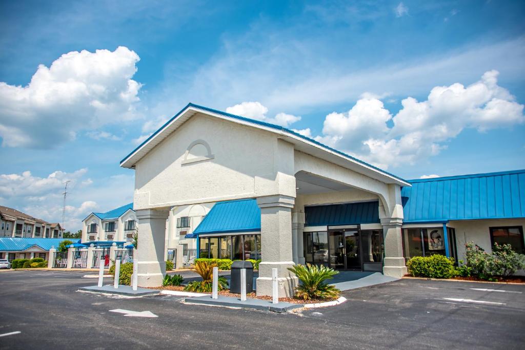 a building with a blue roof and a parking lot at Days Inn by Wyndham Troy in Troy