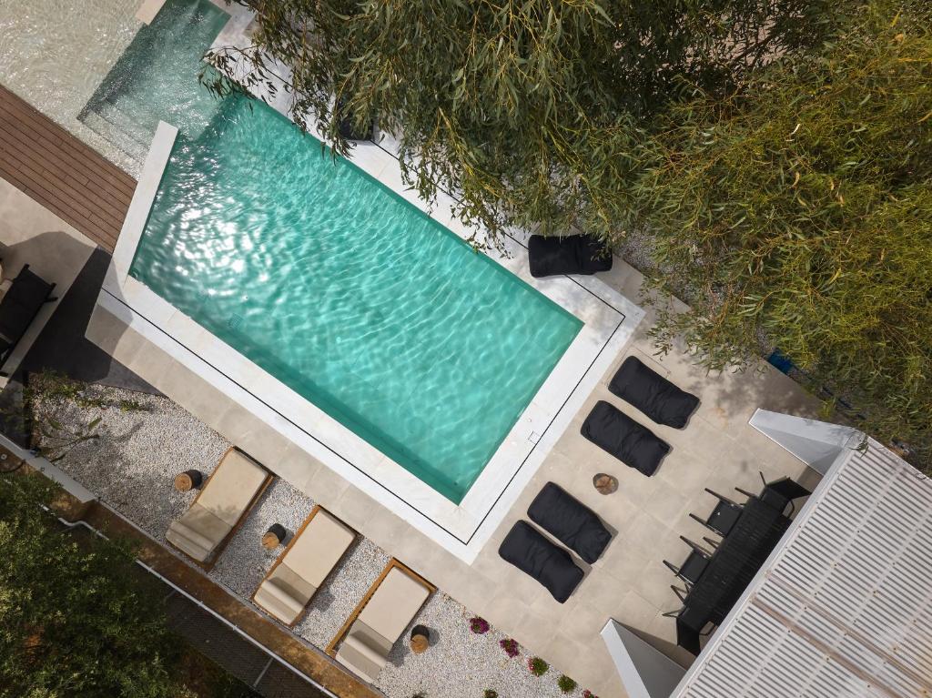 MichELe Luxury apartments by Smaris Collection في ماليا: اطلالة علوية على مسبح مع كراسي وكراسي