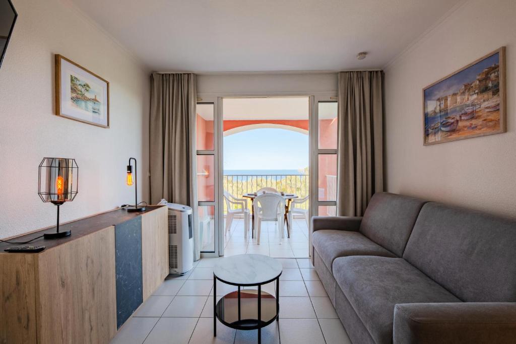 un salon avec un canapé et une table dans l'établissement Résidence le Hameau de Cap Esterel - maeva Home - Studio 4 Personnes - Sélection MAE-0574, à Saint-Raphaël