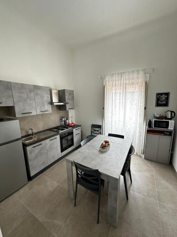 cocina con mesa y sillas en una habitación en Casa Ginestra di Palazzo Biondi, en Giarre